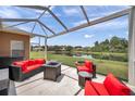 Relaxing screened-in patio with stylish outdoor furniture and serene views of the pond at 9309 Edistro Pl, New Port Richey, FL 34654