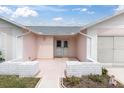 Front entrance to the home featuring a well-maintained walkway and garden beds at 9433 Stonewall Ln, New Port Richey, FL 34655