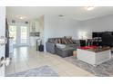 Spacious living room featuring neutral tones, tile flooring, and access to the patio at 9635 Century Dr, Spring Hill, FL 34608