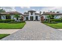Charming home with a beautiful paver driveway, lush landscaping, and attached garages, perfect for comfortable living at 9704 Milano Dr, Trinity, FL 34655