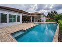 The backyard features a sparkling pool with an outdoor kitchen, perfect for entertaining and relaxing at 9704 Milano Dr, Trinity, FL 34655