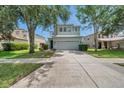 Charming two-story home with a two car garage, well-maintained lawn, and mature shade trees at 9706 Simeon Dr, Land O Lakes, FL 34638