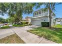 Charming two-story home with a two car garage, well-maintained lawn, and mature shade trees at 9706 Simeon Dr, Land O Lakes, FL 34638