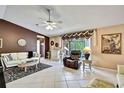 Open living room featuring tile flooring, comfortable seating, and access to the outdoor pool area at 10924 Archway Ave, Hudson, FL 34667