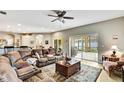 Comfortable living room with a ceiling fan, a large sectional couch, and sliding glass doors to a lanai at 11204 Biddeford Pl, New Port Richey, FL 34654