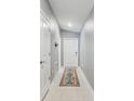 Clean entryway featuring tile flooring, light gray walls, and a decorative rug leading to the front door at 11395 Lavender Loop, Spring Hill, FL 34609