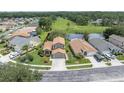 Aerial view of a home with a well-kept lawn, nearby community, and scenic lake at 11418 Tee Time Cir, New Port Richey, FL 34654