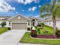 Charming single-story home with a well-manicured lawn, lush landscaping and a two car garage at 14655 Potterton Cir, Hudson, FL 34667