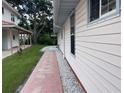 Brick sidewalk leading along the side of the house, well manicured lawn, and gravel at 20971 Negril Ct, Lutz, FL 33558