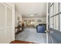 Open-concept living area with blue carpet, features a view of dining and sitting area at 2183 Westchester Blvd, Spring Hill, FL 34606