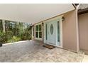 Inviting covered entrance featuring tiled flooring, a decorative front door and large windows at 2202 Amity Ct, New Port Richey, FL 34655