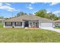 Charming single-story home with a well-manicured lawn and lush flowerbeds enhancing its curb appeal at 2251 Evenglow Ave, Spring Hill, FL 34609