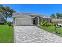 Well maintained single-story home featuring a paved driveway, lush lawn, and meticulously landscaped front yard at 2275 Terrace View Ln, Spring Hill, FL 34606