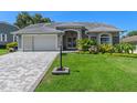 Well maintained single-story home featuring a paved driveway, lush lawn, and meticulously landscaped front yard at 2275 Terrace View Ln, Spring Hill, FL 34606