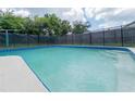 Backyard swimming pool surrounded by a fence and lush green landscaping at 2414 San Luis Rd, Holiday, FL 34691