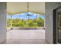 Spacious screened-in lanai with a serene view of the backyard and a ceiling fan at 252 Arbor Woods Cir, Oldsmar, FL 34677