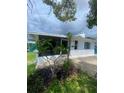 A view of the home's exterior showing the sunroom, plants, siding and a well-manicured lawn at 3530 Beechwood N Ter, Pinellas Park, FL 33781