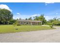 Single-story home with a well-kept lawn and mature trees, situated on a spacious lot at 37722 Granada Ave, Dade City, FL 33525