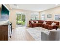 Cozy living room with a comfortable sectional sofa, tile flooring, and a view of the outdoor patio at 3897 Villamore Ln, Odessa, FL 33556