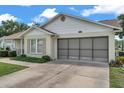 A bright, single-story home with a large screened garage door and a well-maintained lawn at 4646 Lacrosse Ct, New Port Richey, FL 34655