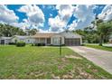 Charming single-story home with screened-in garage, well-maintained lawn, and inviting front porch at 4646 Lacrosse Ct, New Port Richey, FL 34655