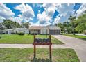 Inviting single-story home with well-kept lawn, featuring screened garage and cozy front porch at 4646 Lacrosse Ct, New Port Richey, FL 34655