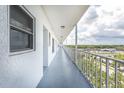 Wide hallway with gray floors, doors, windows, and railings at 4939 Floramar Ter # 812, New Port Richey, FL 34652