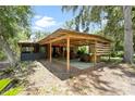 Outdoor space featuring a covered patio, grill area, and lush greenery at 6410 Amelia Ln, Dade City, FL 33523