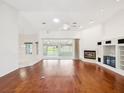 Bright living room featuring hardwood floors, fireplace, and sliding glass doors to the lanai at 6545 North Lake Dr, Zephyrhills, FL 33542