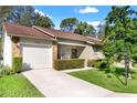Well-maintained home with stone accents, manicured bushes, and a neatly paved driveway at 6590 Brambleleaf Dr, Spring Hill, FL 34606