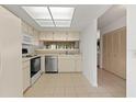 Bright kitchen featuring white appliances, tile floors, and ample cabinet space at 6590 Brambleleaf Dr, Spring Hill, FL 34606
