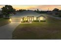 Charming single-story home with a well-maintained lawn and a two-car garage, captured during sunset at 8199 Nordica Rd, Weeki Wachee, FL 34613