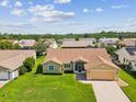 Aerial shot of a home with a well-kept lawn, set in a quiet neighborhood with mature trees at 8401 Pavilion Dr, Hudson, FL 34667