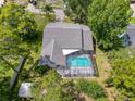 Aerial view of a home featuring a screened-in pool area, nestled among trees, providing a private outdoor retreat at 8979 Hernando Way, Weeki Wachee, FL 34613