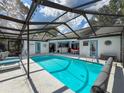 Inviting screened-in pool area with ample seating, a bar, and easy access to both the home and the yard at 8979 Hernando Way, Weeki Wachee, FL 34613