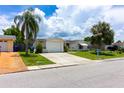 Charming single-story home featuring a one-car garage, mature landscaping, and a well-manicured lawn at 9134 Crabtree Ln, Port Richey, FL 34668