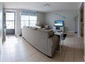 Comfortable living room featuring neutral colors, tile flooring, and lots of natural light from a large window at 9134 Crabtree Ln, Port Richey, FL 34668