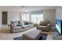 Comfortable living room featuring neutral colors, tile flooring, and lots of natural light from a large window at 9134 Crabtree Ln, Port Richey, FL 34668