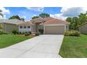 Single-story home featuring well-maintained landscaping and a spacious driveway at 9149 Penelope Dr, Weeki Wachee, FL 34613