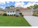 Inviting single-story home with a well-manicured lawn and a two-car garage at 9149 Penelope Dr, Weeki Wachee, FL 34613