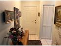 Inviting entryway featuring tiled floors, a front door, closet, and charming decor on a wooden console table at 9474 Nakoma Way # E, Weeki Wachee, FL 34613