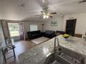 Inviting living room featuring wood-look floors, neutral walls, and a comfortable seating area with an open doorway at 10654 Holgate St, New Port Richey, FL 34654