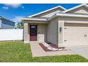 Close-up of a well-maintained single-story home with a two-car garage and manicured landscaping at 12119 Barnsley Reserve Pl, Gibsonton, FL 33534