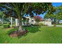 Lovely exterior view of a single-story home featuring a lush green lawn, mature trees, and beautiful landscaping at 14178 Pullman Dr, Spring Hill, FL 34609