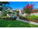 Beautiful front yard with green lawn, flowering tree, and attractive landscaping leading to the home's entryway at 14178 Pullman Dr, Spring Hill, FL 34609