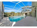 A sparkling in-ground pool, screen enclosed, surrounded by a patio and green space perfect for outdoor relaxation at 14178 Pullman Dr, Spring Hill, FL 34609
