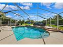 Inviting screened-in pool area with ample seating, a built-in grill, and lush landscaping at 1478 Brigadier Dr, Spring Hill, FL 34608