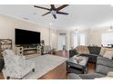 Inviting living room boasts a fireplace, ceiling fan, and ample seating for relaxation and gatherings at 2111 Maximilian Ave, Spring Hill, FL 34609