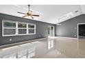 Open-concept living space featuring tile floors, gray paint, and access to outdoor area at 2476 Magellan Ave, Spring Hill, FL 34608