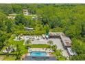 Expansive property featuring a luxurious pool, garage, and lush landscaping from an aerial perspective at 26221 Pheasant Run, Wesley Chapel, FL 33544